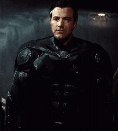 Man In Black Armored Suit Standing In Dark Room GIF
