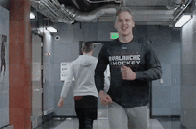 Man In Black Avalanche Hockey Shirt Running In Hallway GIF
