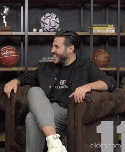 Man In Black Balenciaga Shirt Sitting On Couch GIF