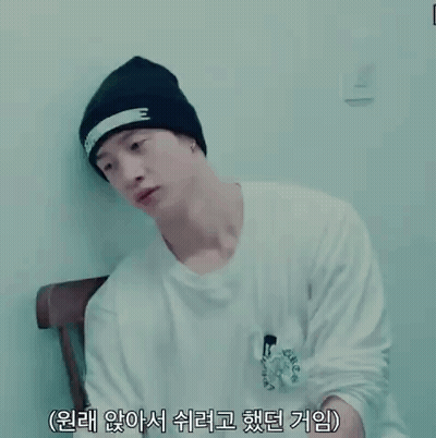 Man In Black Beanie And White Shirt With Chinese Writing Sitting In Chair GIF