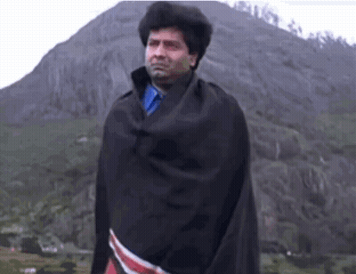 Man In Black Blanket At Mountain GIF