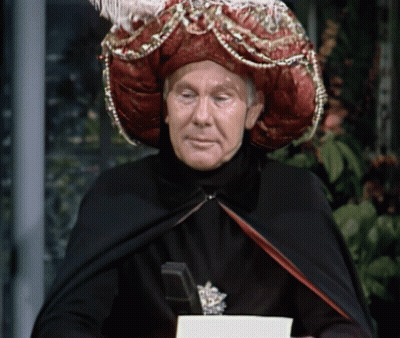 Man In Black Cape And Red Hat Holding Book GIF