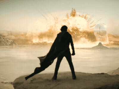 Man In Black Cape On Rock Before Explosion GIF
