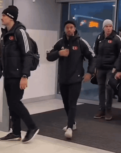 Man In Black CCM Hat Walking With Two Men GIF