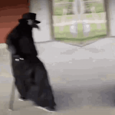 Man In Black Cloak And Top Hat Walking Down Street GIF