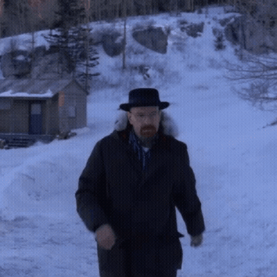 Man in Black Coat and Hat Walking in Snow
