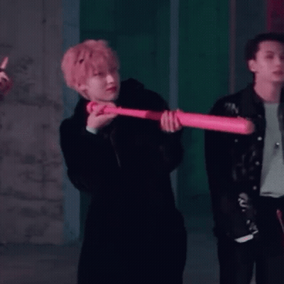 Man In Black Coat Holding Pink Baseball Bat GIF