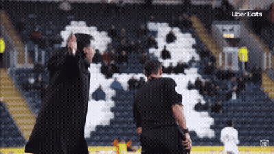 Man In Black Coat In Front Of Uber Eats Logo GIF