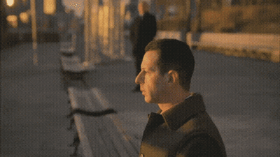 Man In Black Coat On Sidewalk GIF