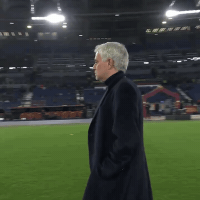 Man In Black Coat On Soccer Field With Hands In Pockets GIF