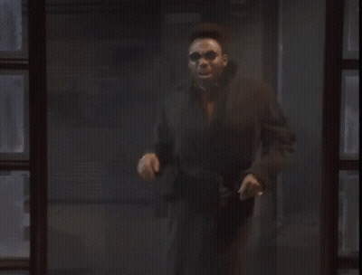 Man In Black Coat Standing By Dark Window GIF