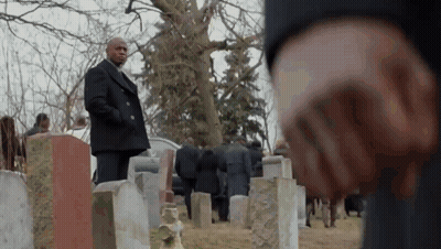 Man In Black Coat Standing In Cemetery With Crowd GIF
