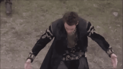 Man In Black Coat Standing On Dirt Field GIF