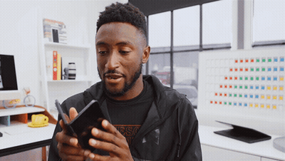 Man In Black Guess Jacket Looking At Phone GIF