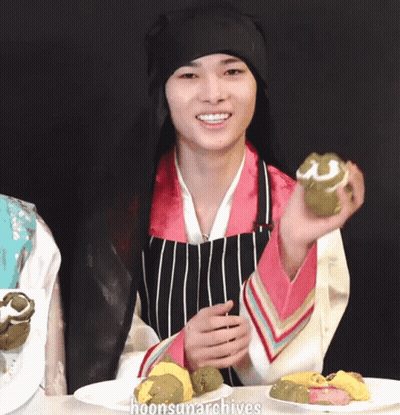 Man In Black Hat And Apron Holding Green Cookie GIF