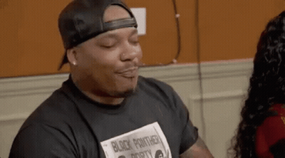 Man In Black Hat And Black Panther T-Shirt Sitting With Woman GIF
