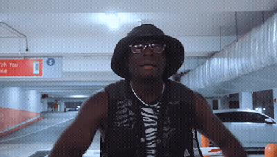 Man In Black Hat And Glasses In Parking Garage GIF