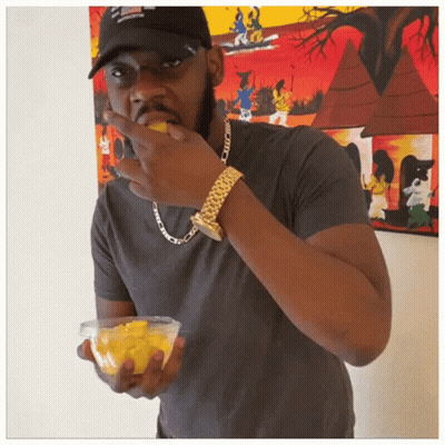 Man In Black Hat And Gold Watch Eating Fruit GIF
