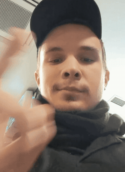 Man In Black Hat And Scarf Looking At Camera GIF