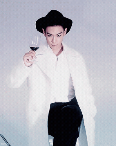 Man In Black Hat And White Coat Holding Wine GIF