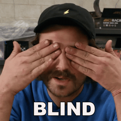 Man in Black Hat Covering Eyes Saying Blind