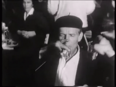 Man In Black Hat Drinking At Table GIF