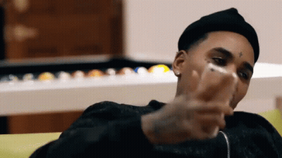 Man In Black Hat Looking At Phone On Couch GIF