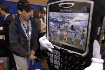 Man In Black Hat Next To Giant Blackberry GIF