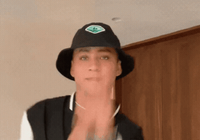 Man In Black Hat With Green Sticker GIF