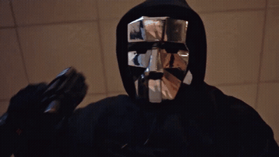 Man In Black Hoodie And Silver Mask Holding Gun GIF