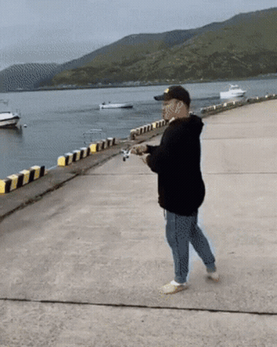 Man In Black Hoodie And Yellow Hat Fishing GIF