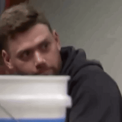 Man In Black Hoodie Looking Behind White Bucket GIF