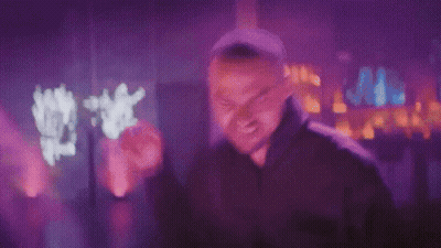 Man In Black Hoodie Making Funny Face In Purple Light GIF