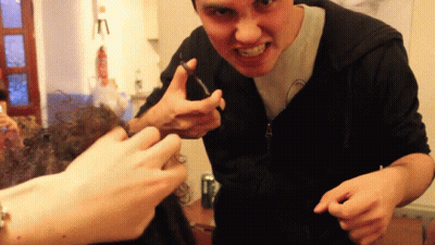 Man In Black Hoodie Making Funny Face With Scissors GIF