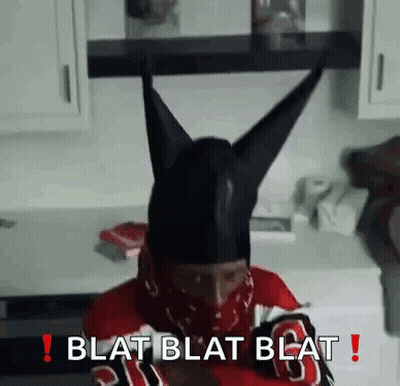 Man In Black Horned Hat And Bandana Sitting In Kitchen GIF