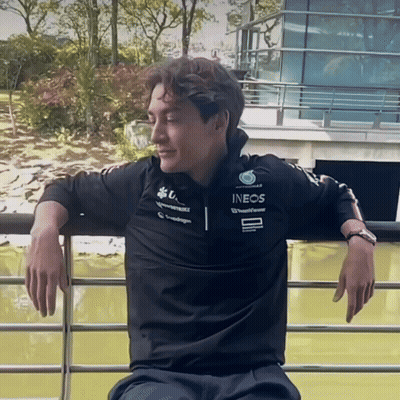 Man In Black Ineos Shirt Leaning On Railing GIF