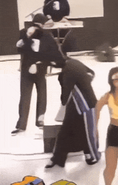 Man In Black Jacket And Blue Pants With Woman In Yellow Tank Top GIF