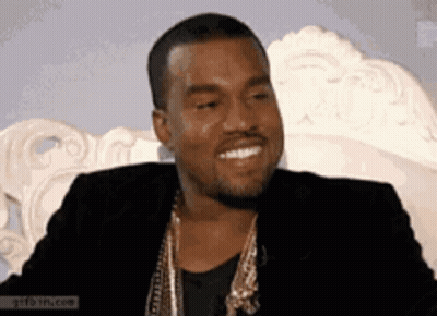 Man In Black Jacket And Gold Chains Smiling GIF