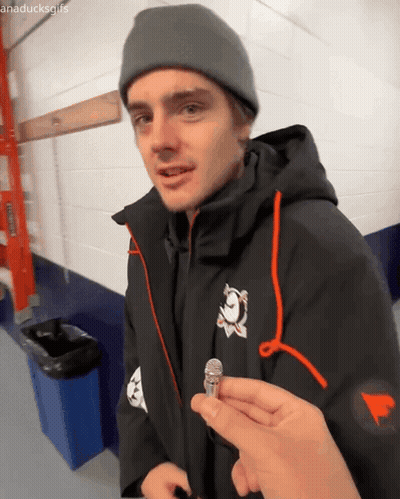Man In Black Jacket And Grey Beanie Holding Microphone GIF