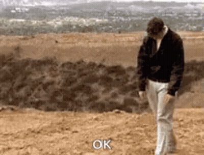 Man In Black Jacket And White Pants Saying Ok GIF