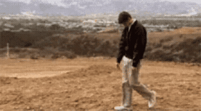Man In Black Jacket And White Pants Walking GIF