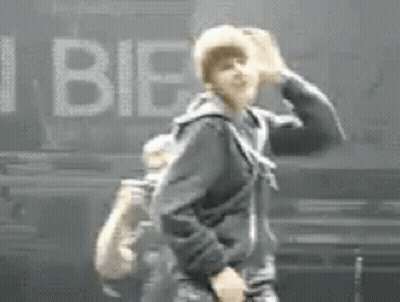 Man In Black Jacket Beside I Bieber Sign GIF