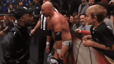 Man In Black Jacket Beside Wrestler In Ring GIF