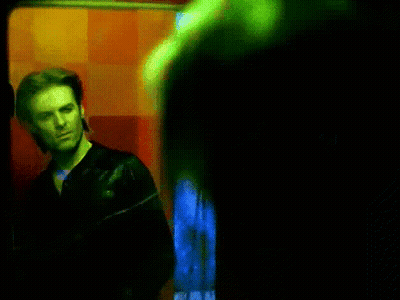 Man In Black Jacket By Red Wall GIF