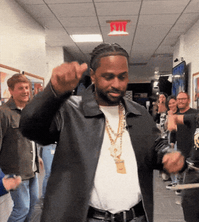 Man In Black Jacket Dancing Under Red Exit Sign GIF