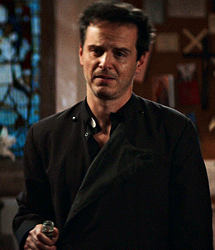 Man In Black Jacket Holding Chest GIF