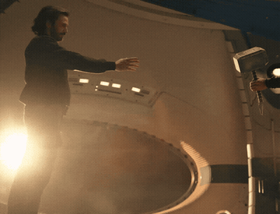 Man In Black Jacket Holding Hammer In Dark Room GIF