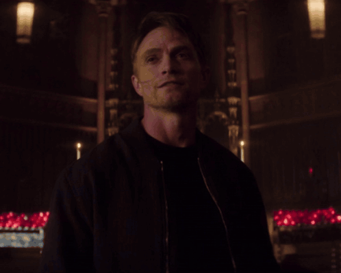 Man in Black Jacket in Dark Room With Candles