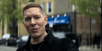 Man In Black Jacket In Front Of Domino Building GIF