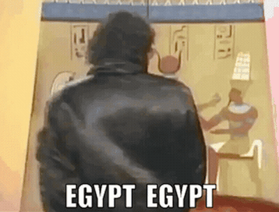 Man In Black Jacket In Front Of Egyptian Painting GIF